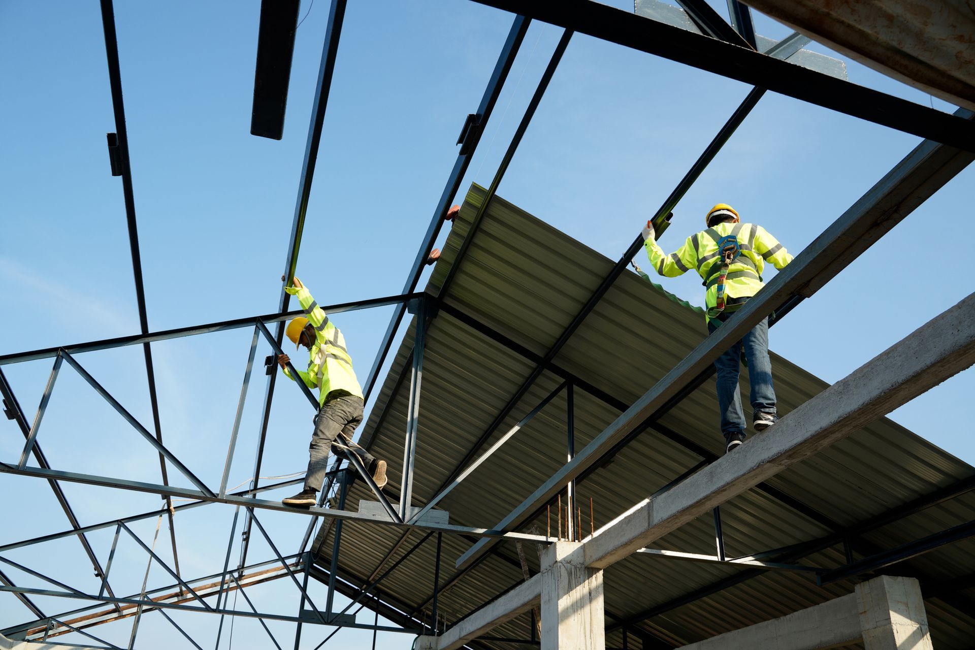 Crew installing metal roof panels on a commercial structure